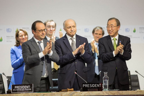 Il presidente francese, Francois Hollande, il ministro degli esteri e presidente della Cop21, Laurent Fabius e il segretario generale ONU, Ban Ki-moon applaudono dopo l'annuncio dell'accordo finale. Foto: UNFCCC